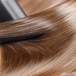 Cabelo liso e brilhante sendo alongado com ferramenta profissional.